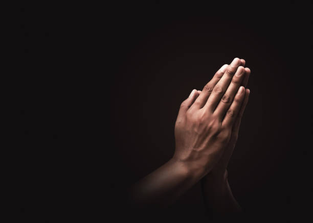 praying-hands-with-faith-in-religion-and-belief-in-god-on-dark-power-picture-id1181376545